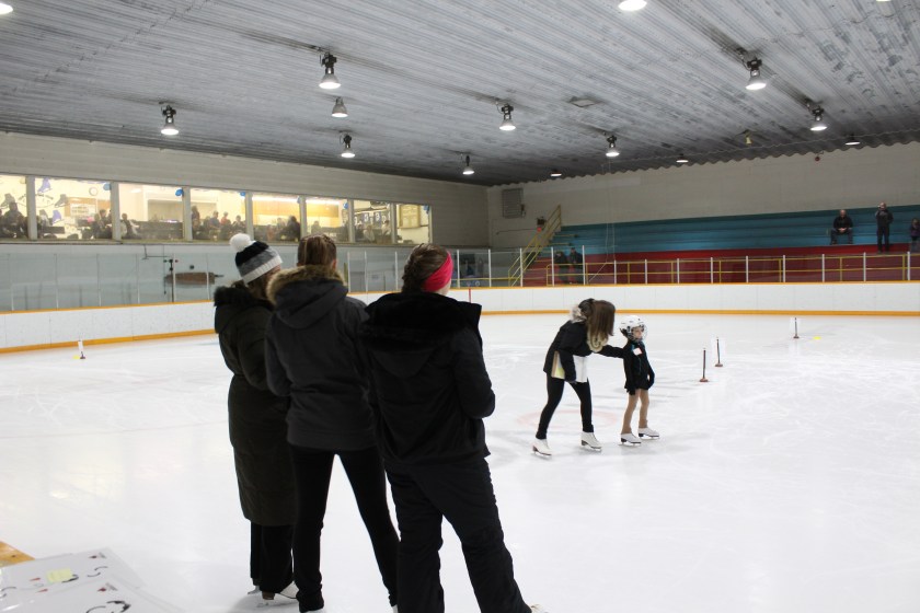 Coach, Erin Bay, helps a CanSkater under the watchful eye of the judges. (Photo credit:Tammy Karatchuk)